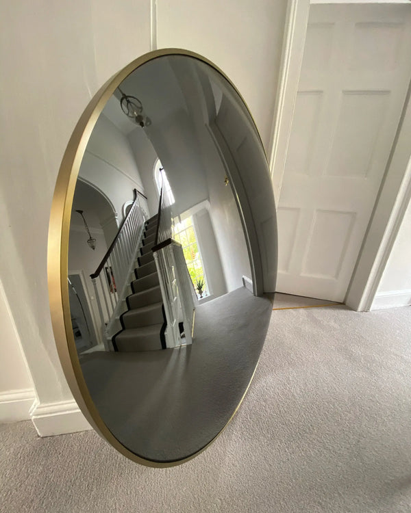 Blue decorative convex mirror on a modern living room wall.