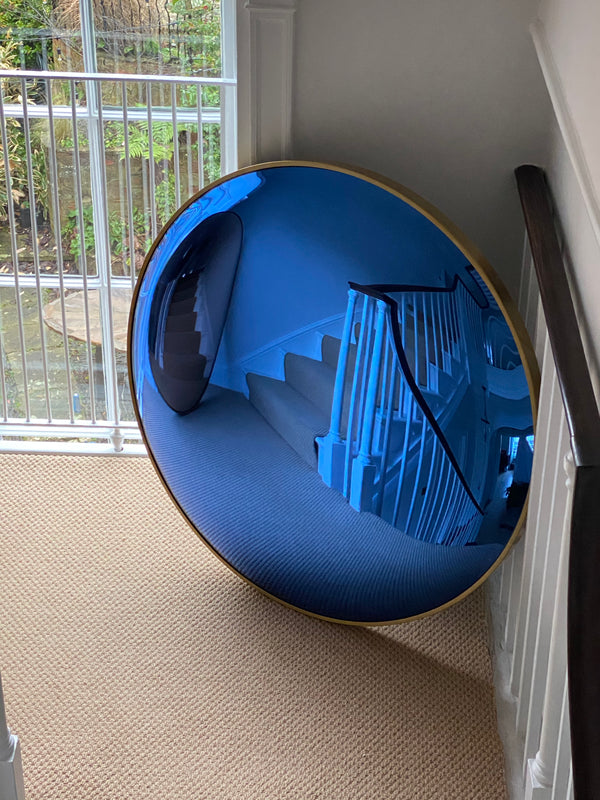 A detailed shot of a convex mirror highlighting its reflective surface and elegant frame.