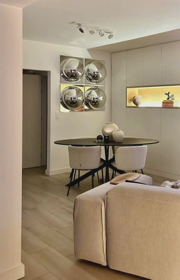 Modern dining room wall decor with four silver convex mirrors.