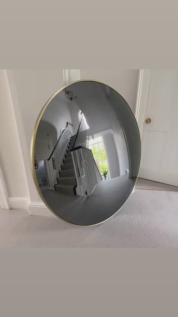 Floor standing antique convex mirror reflecting a home interior.