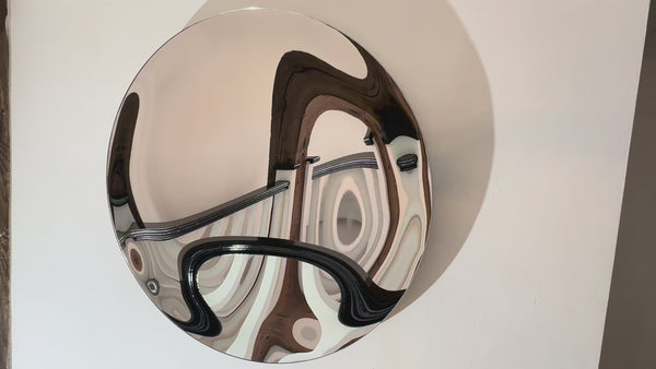 Round silver convex mirror wall art with abstract distortions.